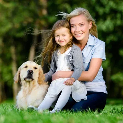 mother and daughter playing outside with dog